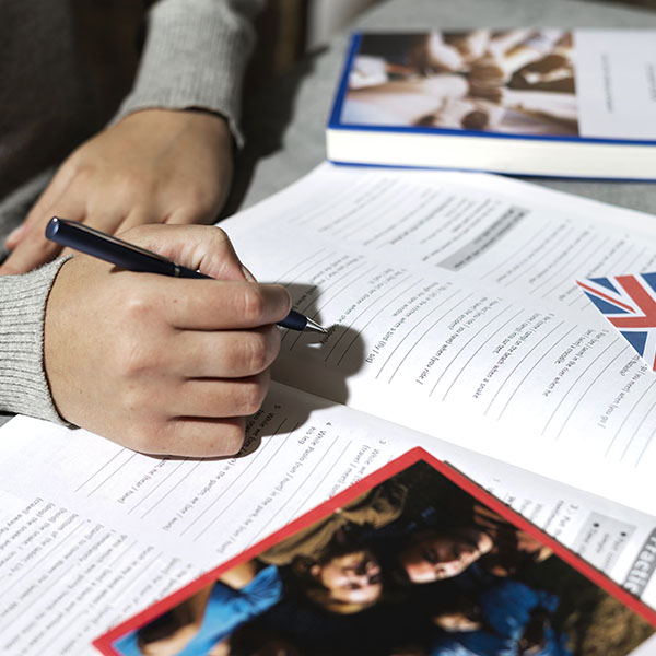 Alumno escribiendo en un workbook de inglés